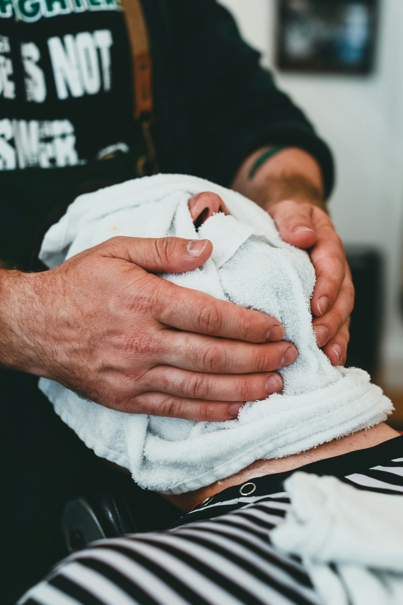 Customer under a hot towel before a shave