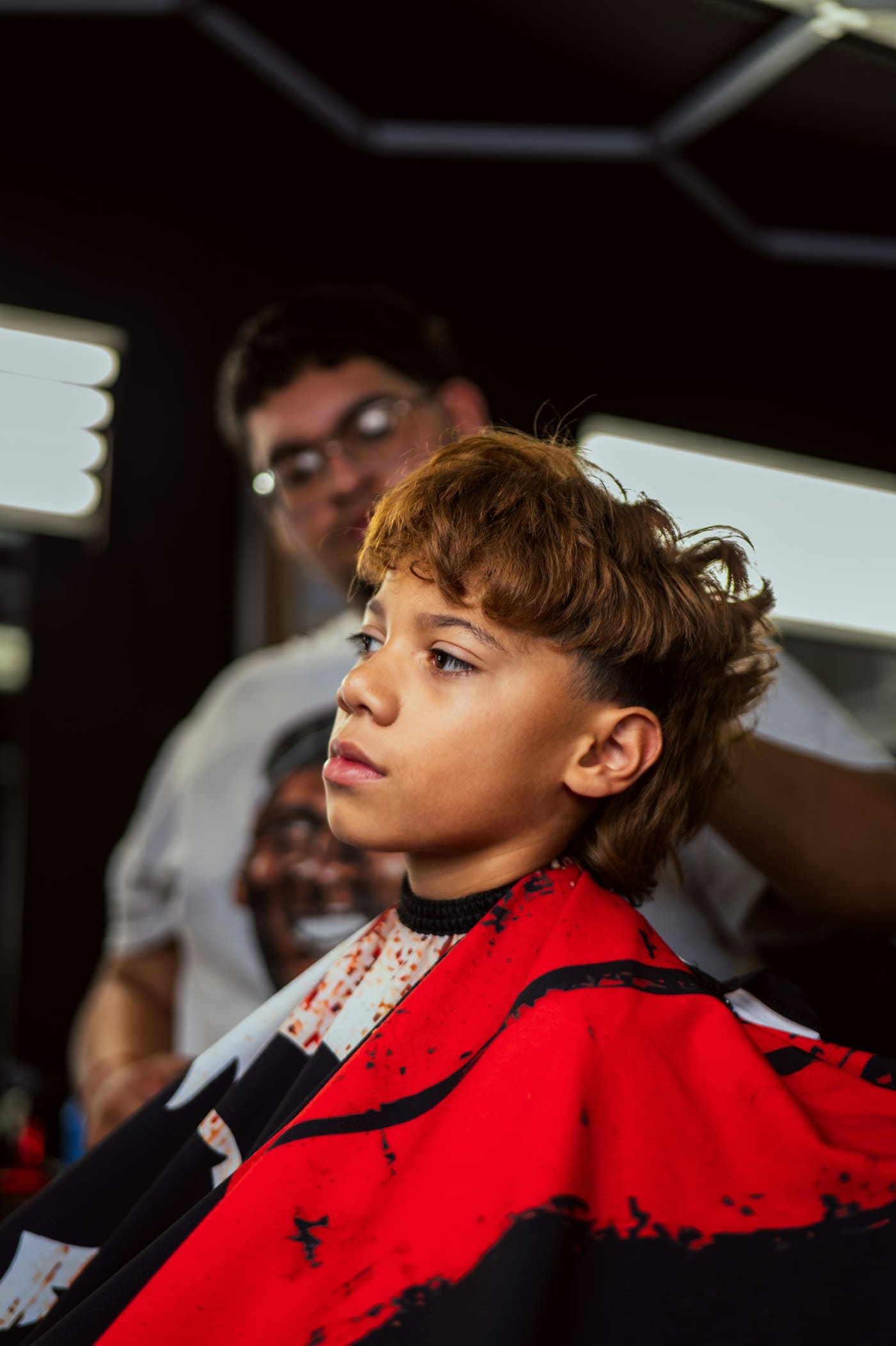 Boy in a barber cape after a textured cut