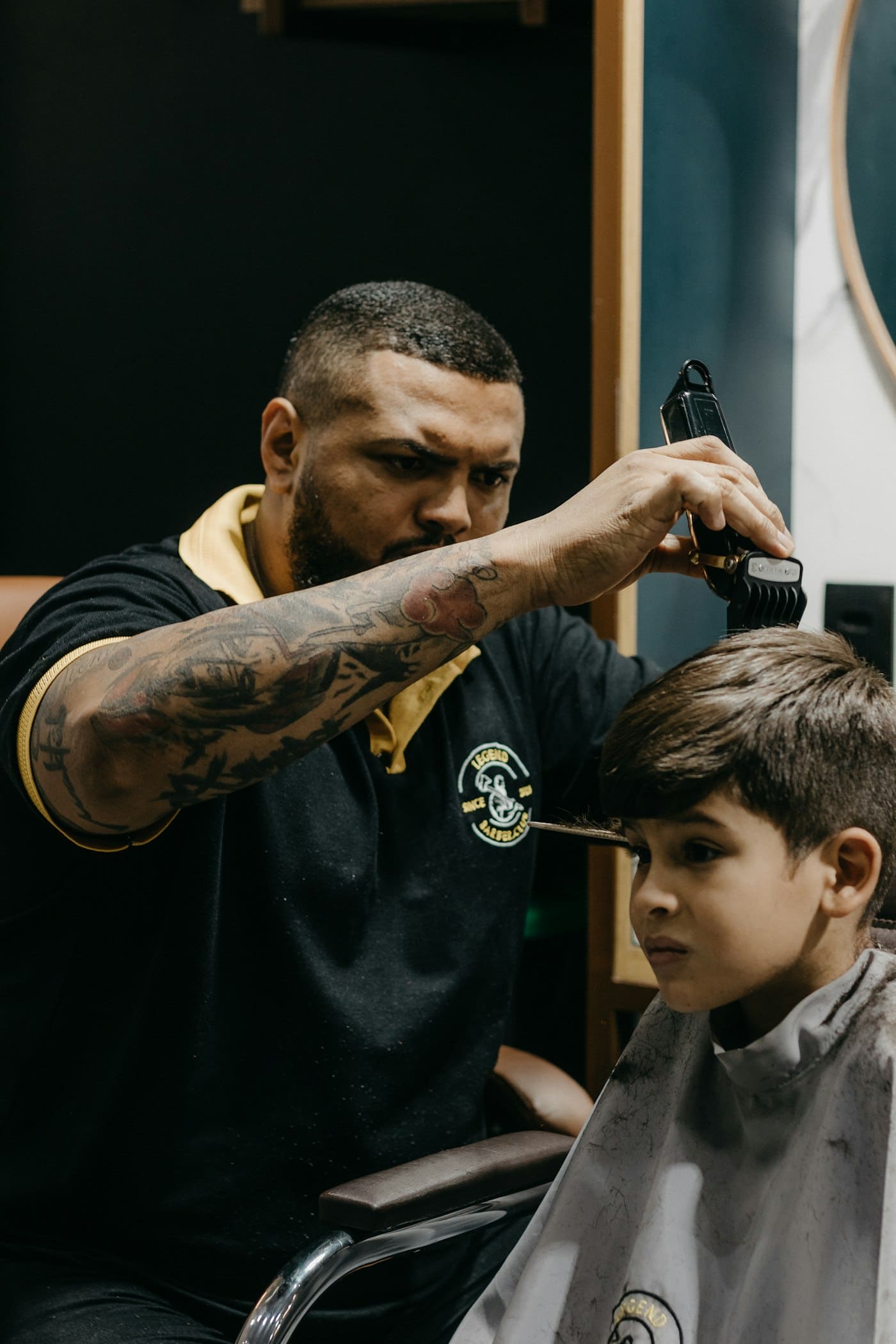 Barber fading a boy's hair with clippers